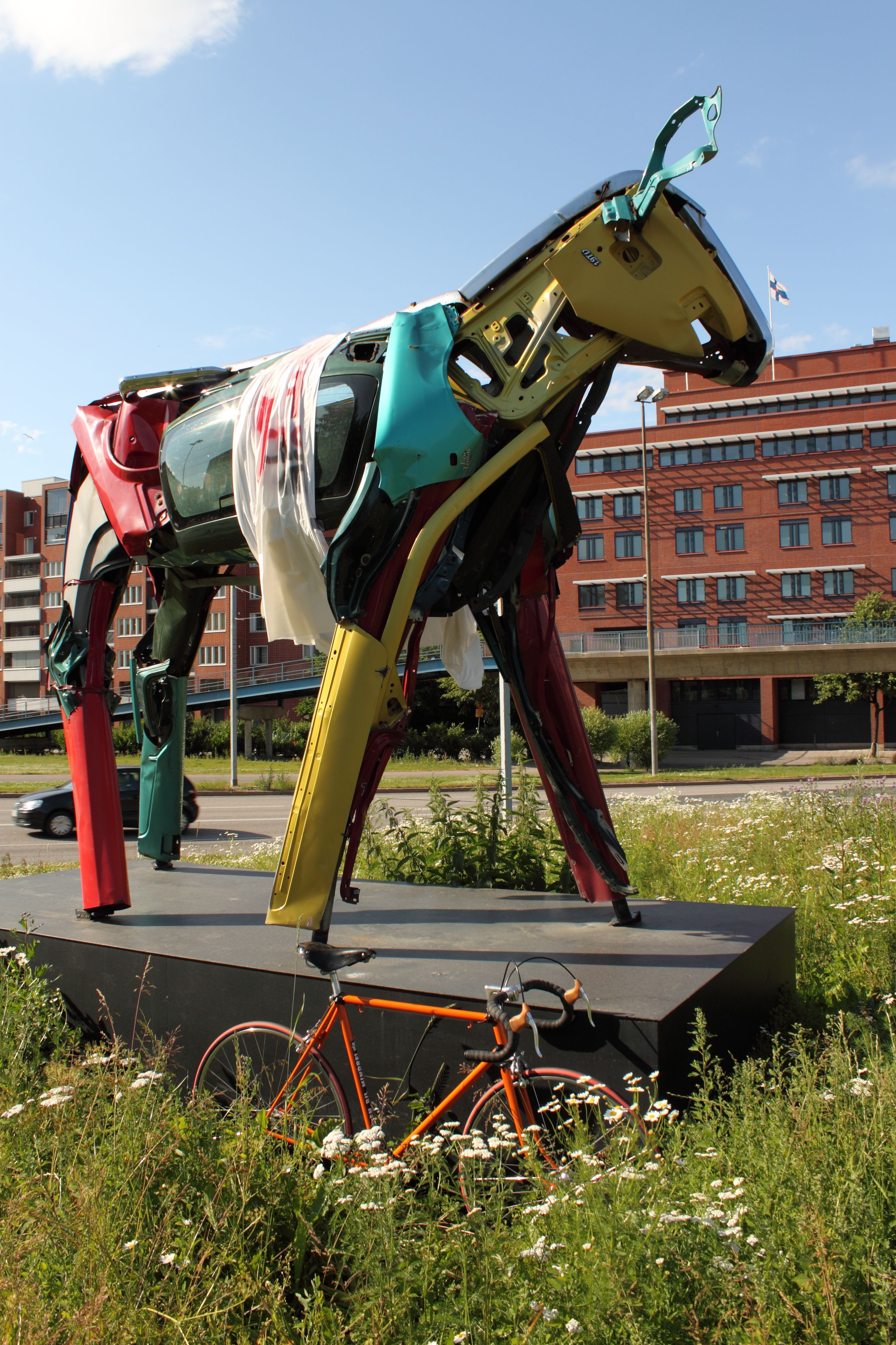 Staty av en ko byggd av bildelar